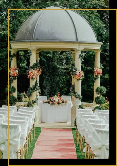 Outdoor wedding ceremony setup with a white gazebo and red aisle